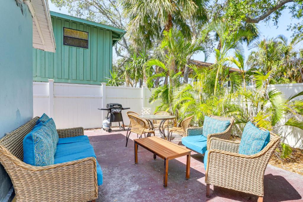 a patio with wicker chairs and a table with blue pillows at Walk to Beaches & Gulf: Indian Rocks Beach Duplex! in Clearwater Beach