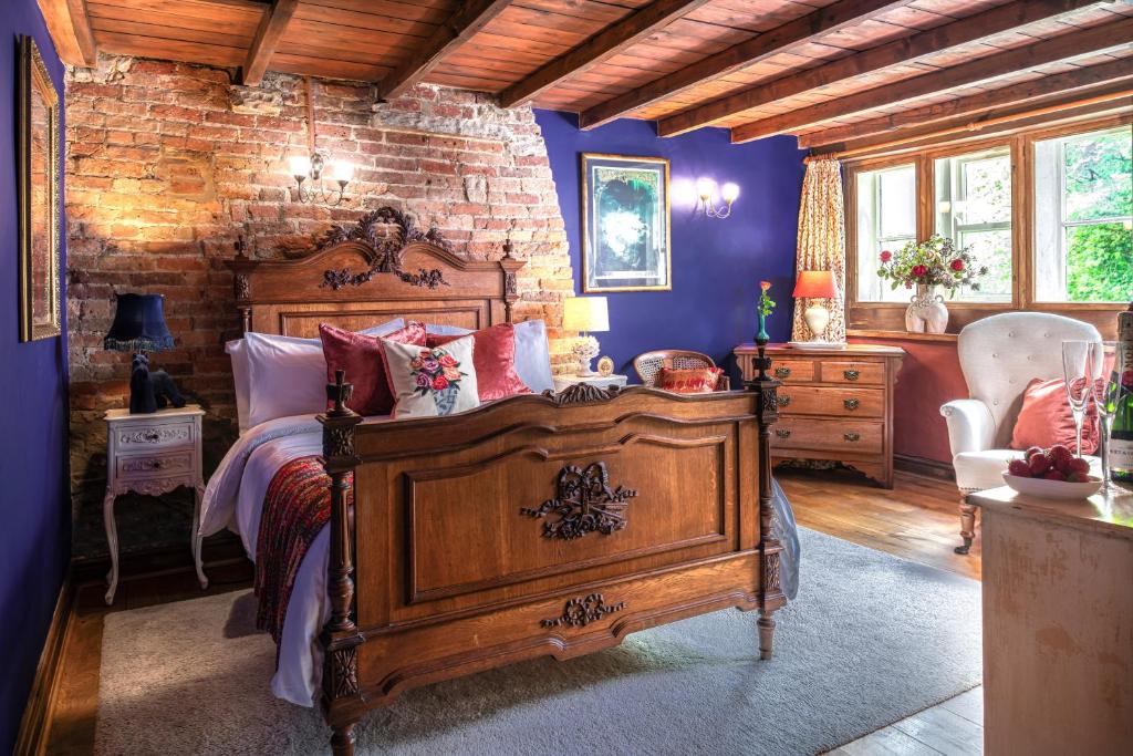 a bedroom with a wooden bed and a brick wall at Historic Hidden Gem-10mins walk to Holmfirth, Log Burner,Easy Parking in Holmfirth