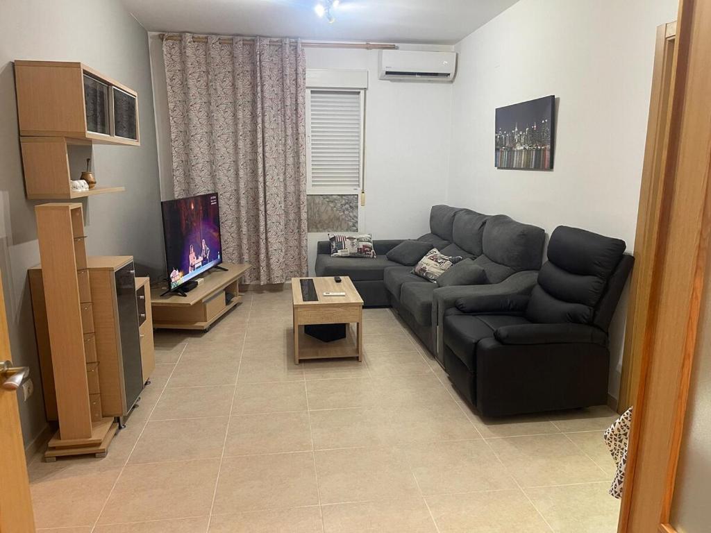 un soggiorno con un divano e una TV di Acogedor piso en Benissanó a Benisanó