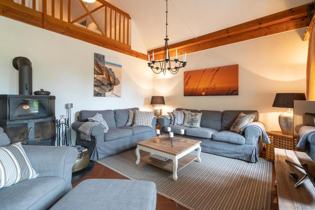 a living room with blue couches and a wood stove at Friederikenhof in St. Peter-Ording