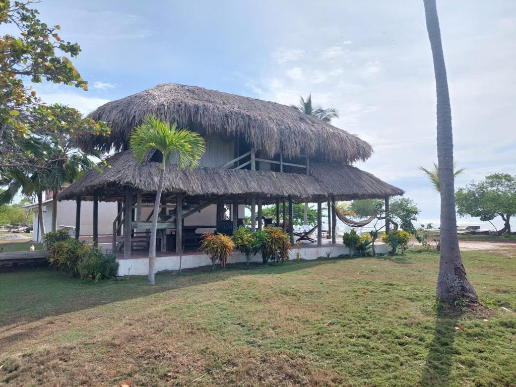 a house with a straw hut with a grass roof at Cabaña ecológica frente al mar en isla fuerte in Isla Fuerte