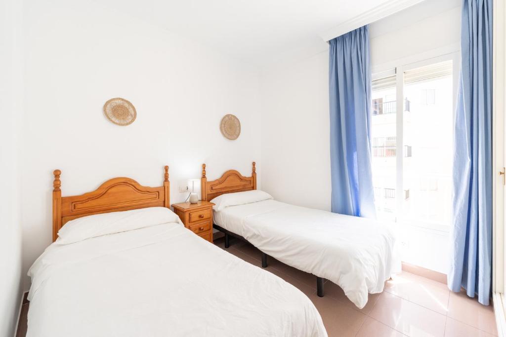 a bedroom with two beds and a window at Apartamentos Solset Nerja in Nerja