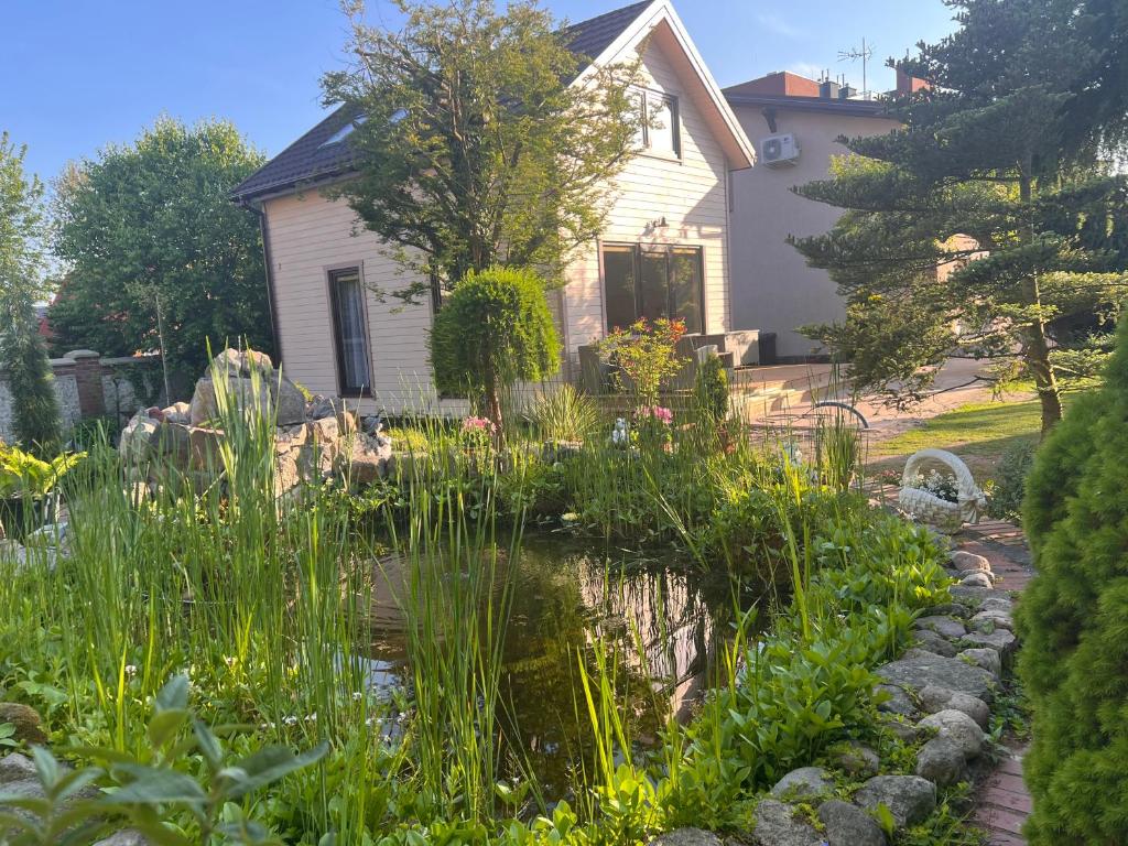 un giardino con laghetto di fronte a una casa di Domek Willa Garden a Ustronie Morskie