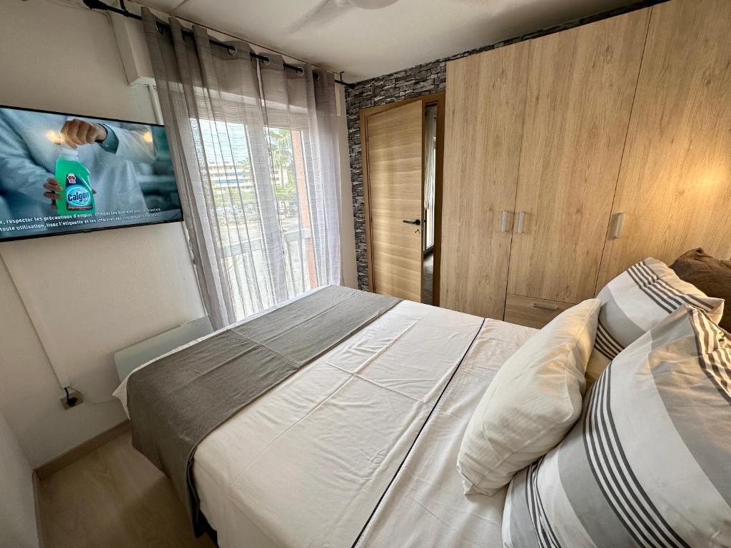 une chambre avec un lit et une télévision à écran plat dans l'établissement Appartement port Hermes Frejus, à Fréjus