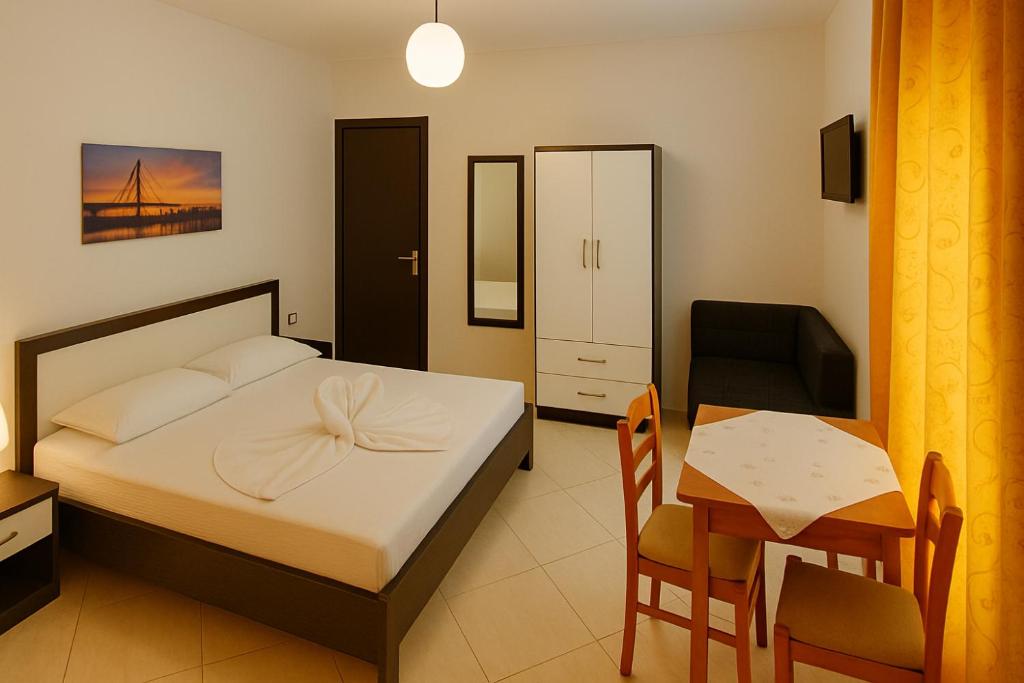 a bedroom with a bed and a table and a chair at Villa Zeka Ksamil in Ksamil