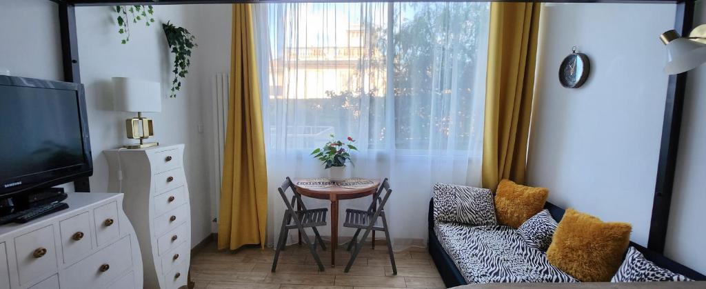 salon ze stołem i krzesłami oraz oknem w obiekcie STUDIO- NICE MONT BORON, PISCINE SUR LA RESIDENCE w Nicei