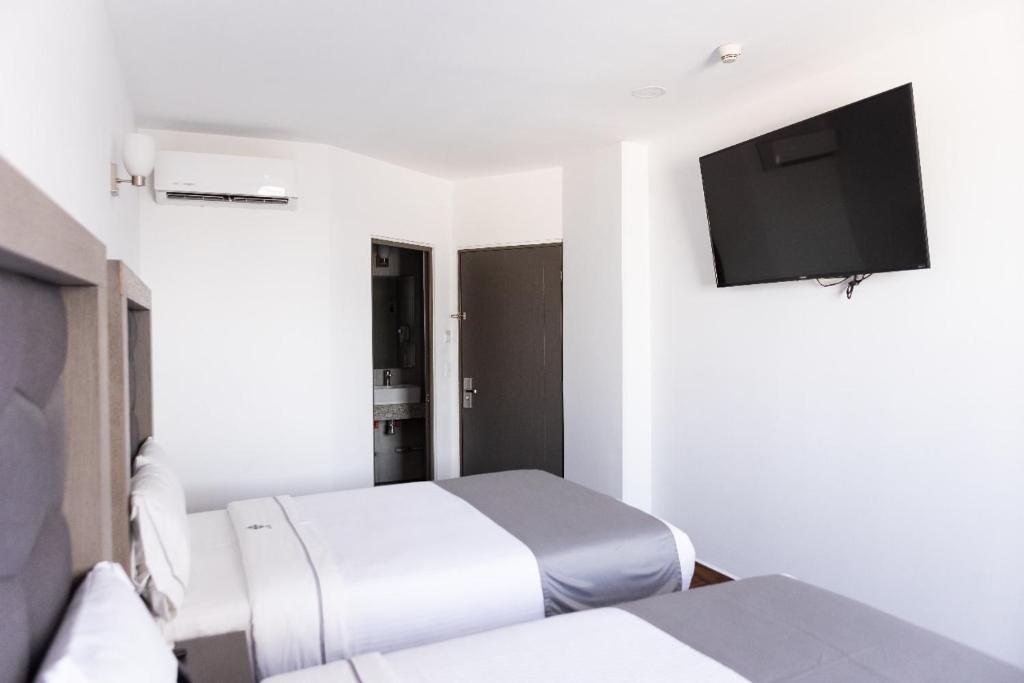 TV a/nebo společenská místnost v ubytování Hotel Bugari Aeropuerto Guadalajara