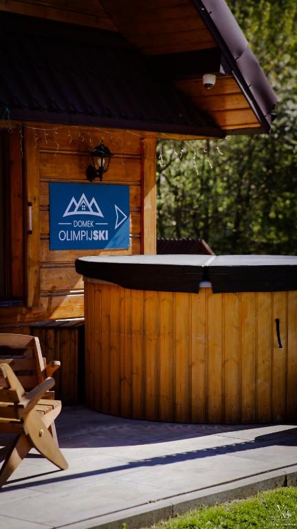 a log cabin with a sign on the front of it at Domek OlimpijSki SZCZYRK in Szczyrk
