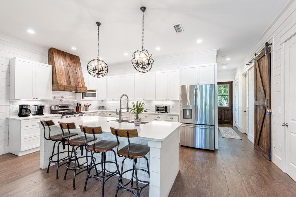 eine Küche mit weißen Schränken und eine Insel mit Barhockern in der Unterkunft 9 E Willow Mist in Preserve at Inlet Beach in Inlet Beach