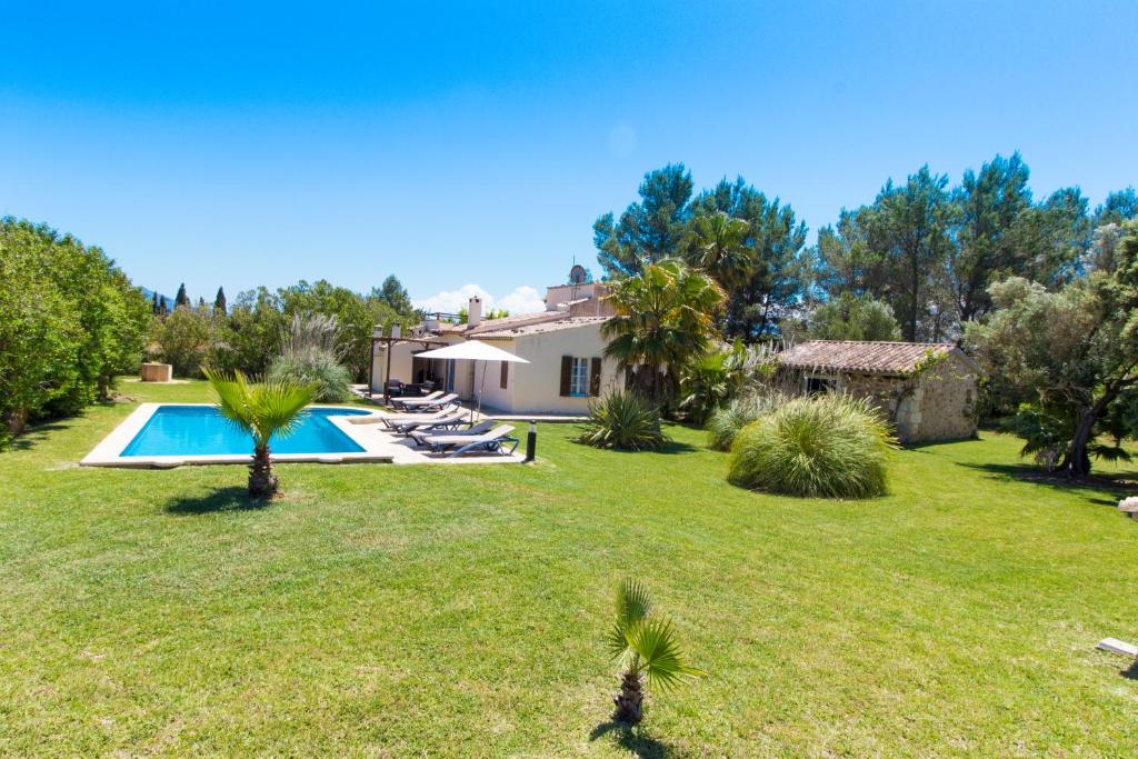 a house with a yard with a swimming pool at Charming villa with A/C and WIFI in Pollença