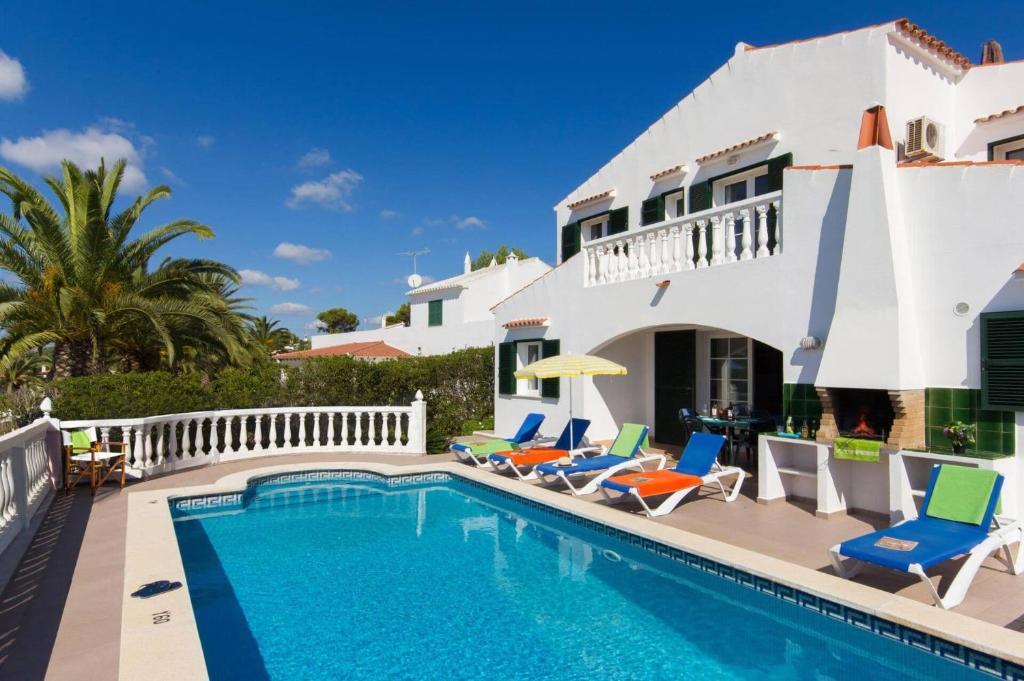 a villa with a swimming pool in front of a house at Villa Girasol by Villa Plus in Alaior