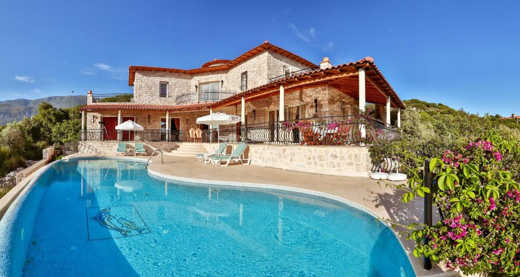 una casa con piscina frente a una casa en Villa Çınarlar en Kas