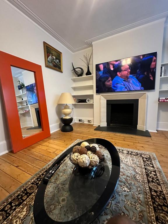 un soggiorno con TV e tavolino da caffè di Cosy Double Bedroom in Little Venice, Maide Vale a Moffat