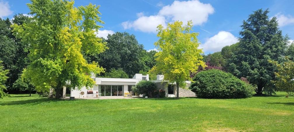 une maison dans un champ planté d'arbres et d'herbe dans l'établissement Maison d'architecte avec foret et immense jardin, à Saintes