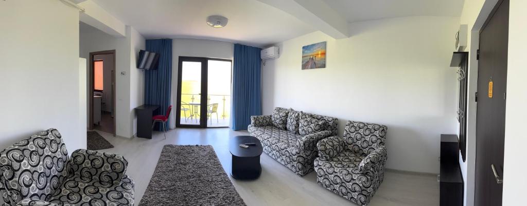 ein Wohnzimmer mit zwei Stühlen und einer Couch in der Unterkunft Luna 21 Eforie Nord in Eforie
