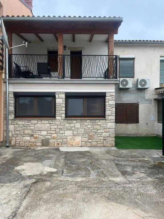 a brick house with a balcony and a balcony at Apartman Luce in Šišan
