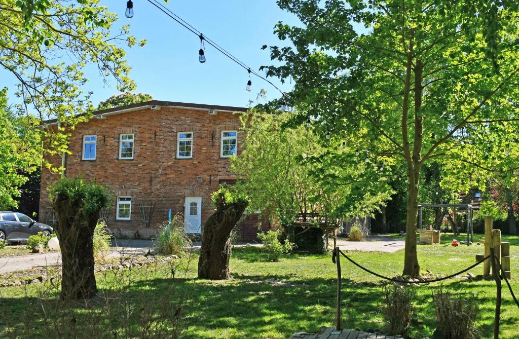 an old brick building with trees in front of it at Ferienwohnungen auf Rügen und nahe Stralsund in Poppelvitz