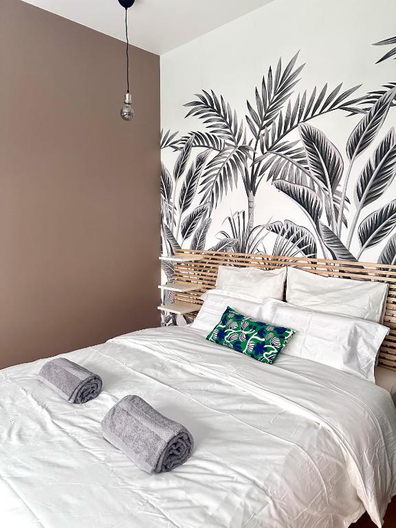 une chambre avec un lit blanc avec deux oreillers dessus dans l'établissement Urban Oasis Paris, à Paris