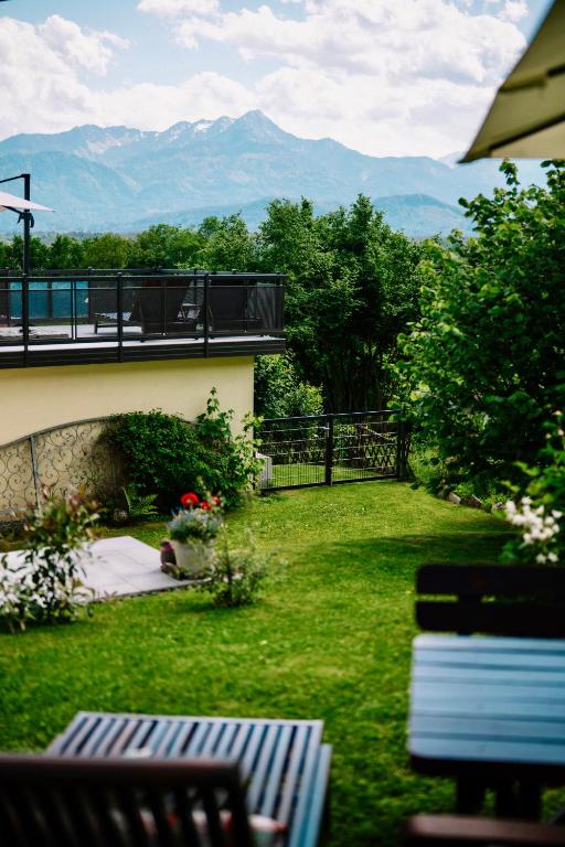 a yard with a balcony with a view of mountains at Schwalbennest Velden in Velden am Wörthersee