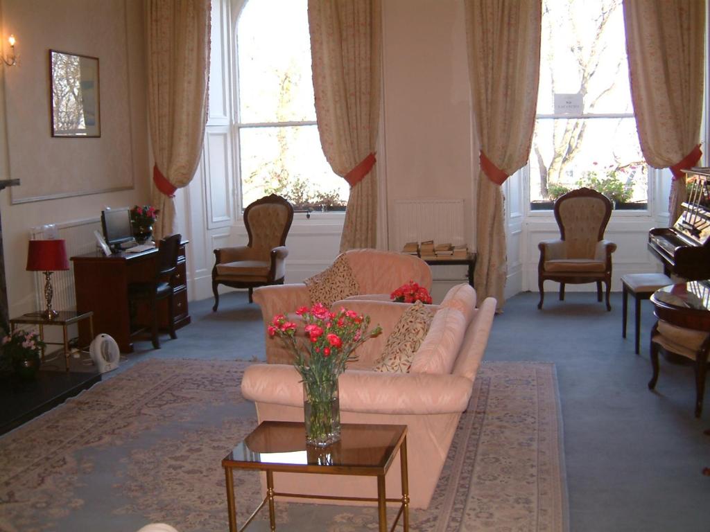 una sala de estar con sofá y un jarrón de flores en Terrace hotel, en Edimburgo