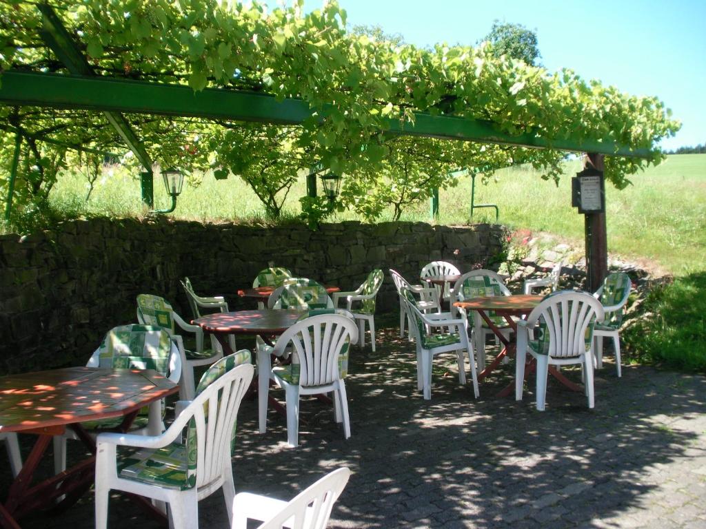 a group of tables and chairs under an umbrella at Hotel Restaurant Biesenbach in Wipperfürth