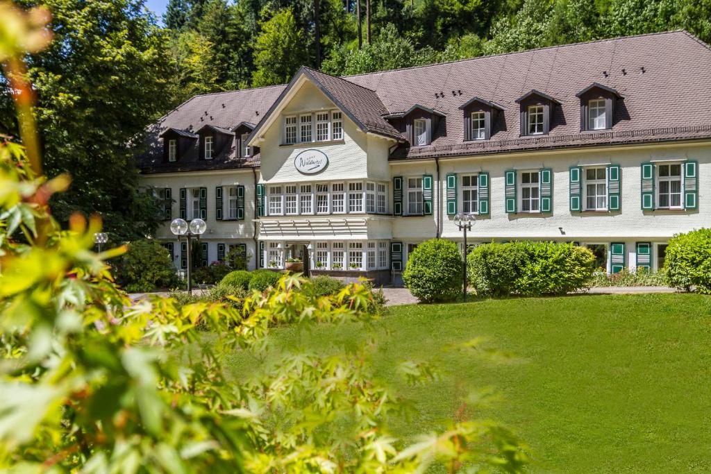 un gran edificio con un reloj en la parte delantera en Waldhotel Bad Sulzburg en Sulzburg