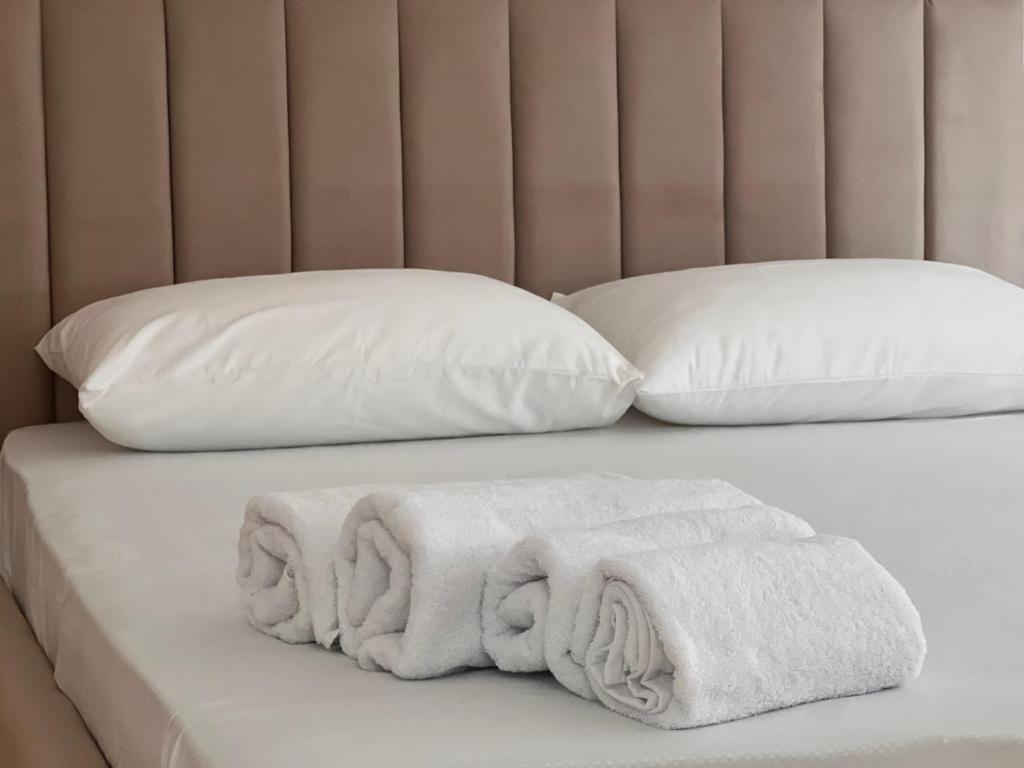 - Toalla blanca en una cama con 2 almohadas en Apartamente me qera Golem, en Golem
