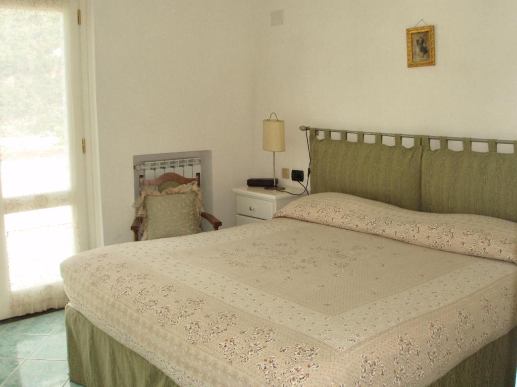 une chambre avec un lit, une chaise et une fenêtre dans l'établissement Villa with Breathtaking Sea View, à Maratea