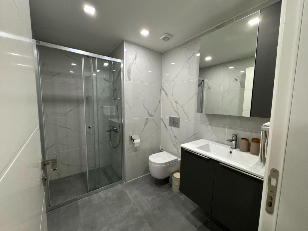 une salle de bain avec une douche, des toilettes et un lavabo dans l'établissement Wakacyjny apartament w Courtyard Long Beach Holiday Resort, à Iskele