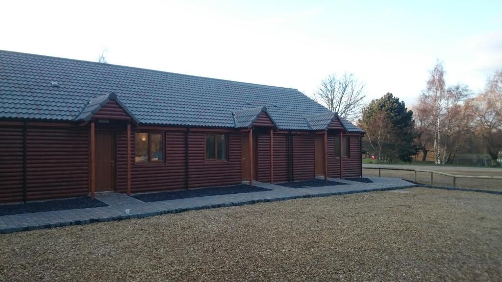 a large wooden cabin with a lot of windows at Woodland Waters in Ancaster