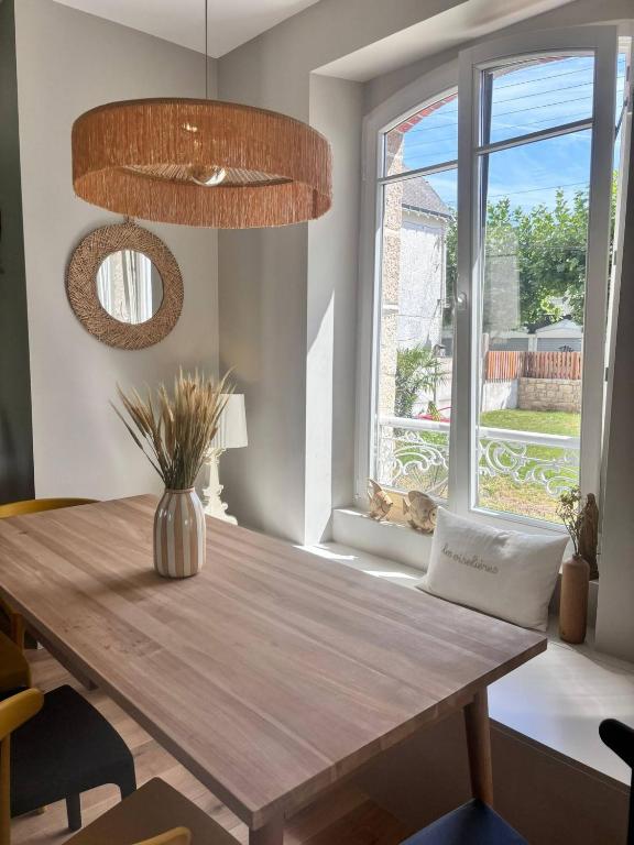 une salle à manger avec une table en bois et une fenêtre dans l'établissement Les oiselieres, plages a pieds, à Carnac