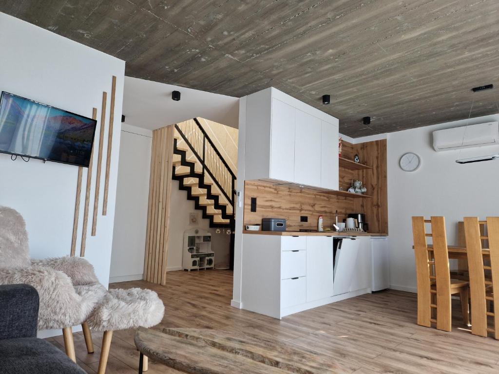 una sala de estar con armarios blancos y una escalera en Domki na Wypasie - Jaworki, en Jaworki