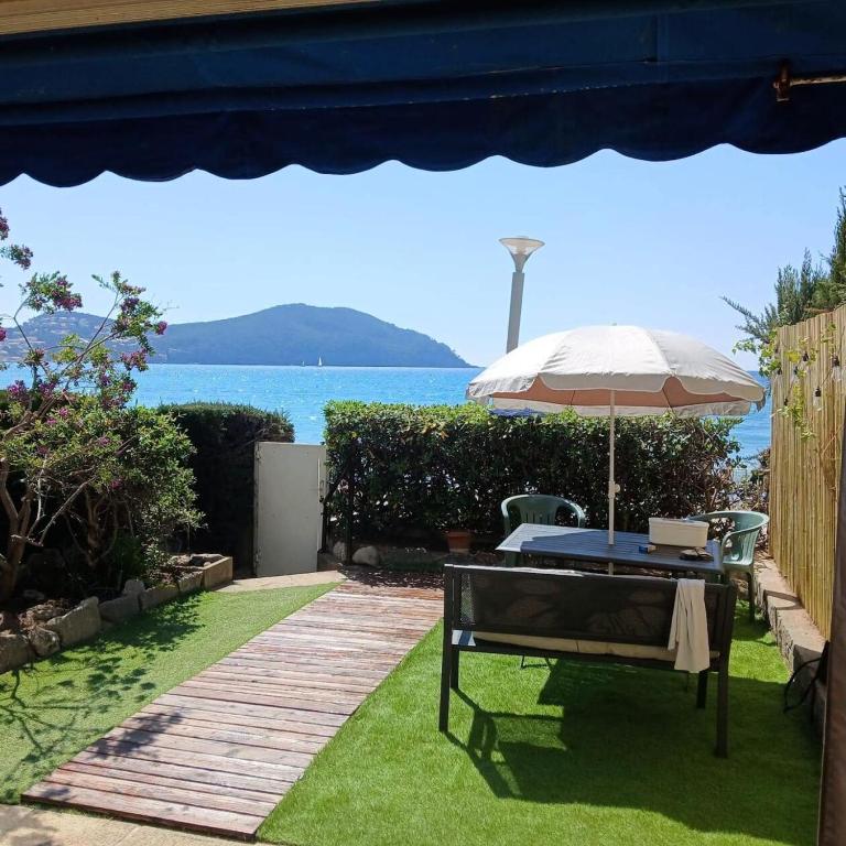 un patio avec un parasol, une table et des chaises dans l'établissement Résidence La Plage La Maisonnette - Joli T2 avec jardin avec un accès direct a la mer MAE-1923, aux Lecques
