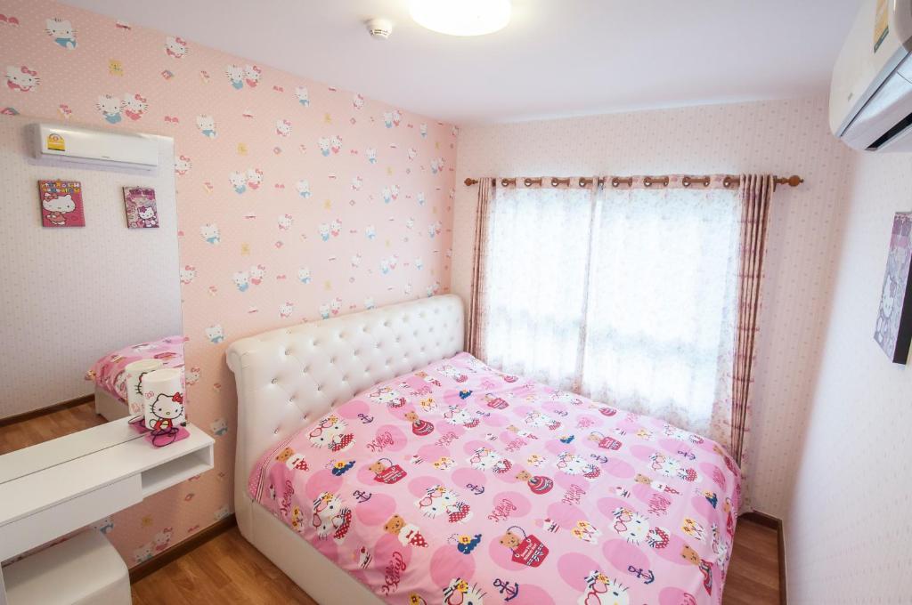 a small bedroom with a pink bed and a window at The Trust Hua Hin kitty room in Hua Hin