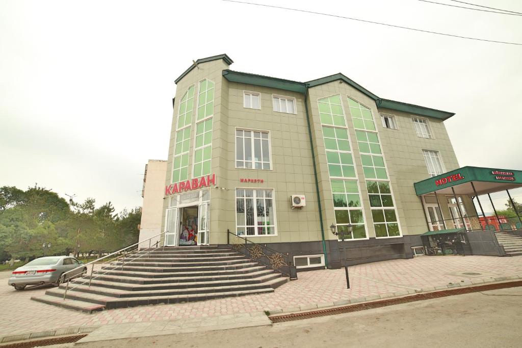 a large building with stairs in front of it at Caravan Hotel in Karakol