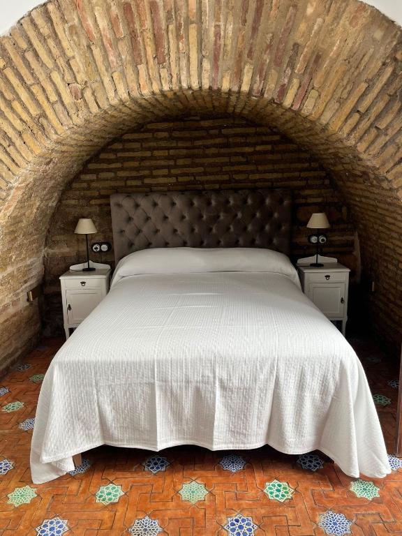 a bedroom with a large white bed with two night stands at Home Sweet Casa de los Arcos Parking Free in Córdoba