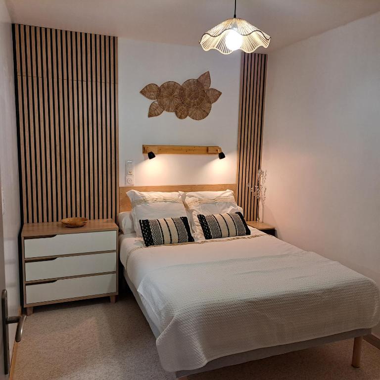 une chambre avec un lit et un lustre dans l'établissement Ty Colibri Lannion, à Lannion