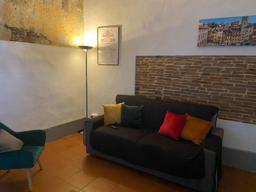 a living room with a couch with colorful pillows at Casa Vacanze Michelangelo in Laterina