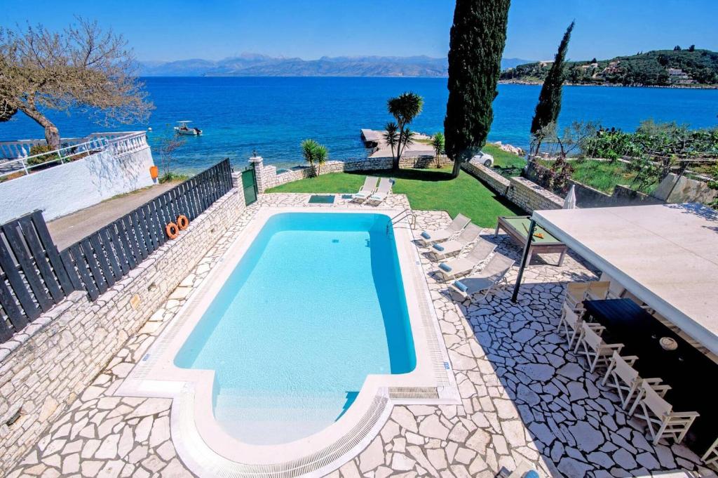 a swimming pool with the ocean in the background at Villa Annie by Villa Plus in Kassiopi