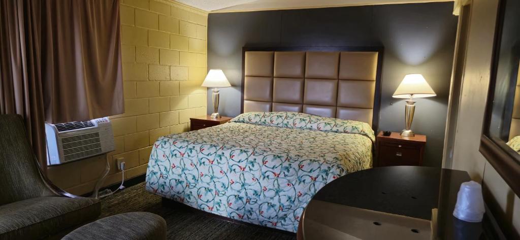 a hotel room with a bed and a table at Bama Motel Mobile I-65 & US-90 in Mobile