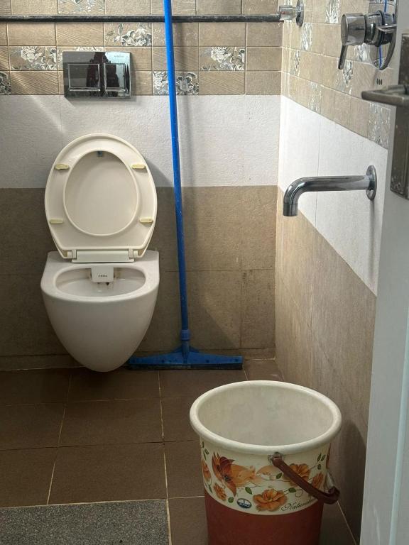 a bathroom with a toilet and a bucket at Sapthagiri Euphoria in Chikmagalūr