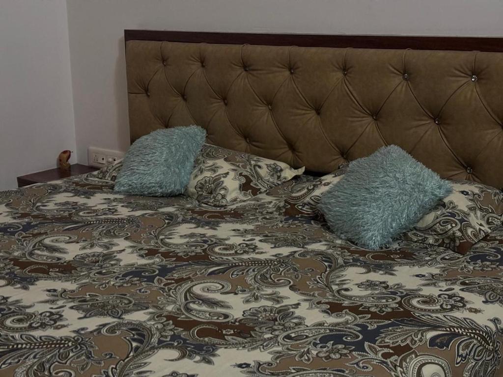 a bed with two blue pillows on top of it at Sapthagiri Euphoria in Chikmagalūr