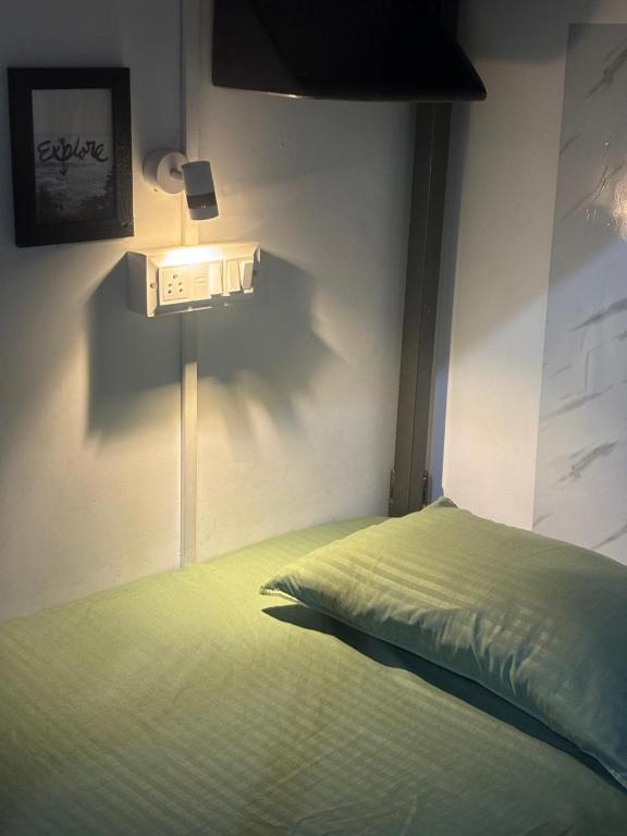 a bedroom with a green bed with a light on the wall at Sapthagiri Euphoria in Chikmagalūr