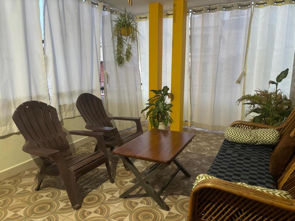 a living room with two chairs and a table and a couch at Sapthagiri Euphoria in Chikmagalūr