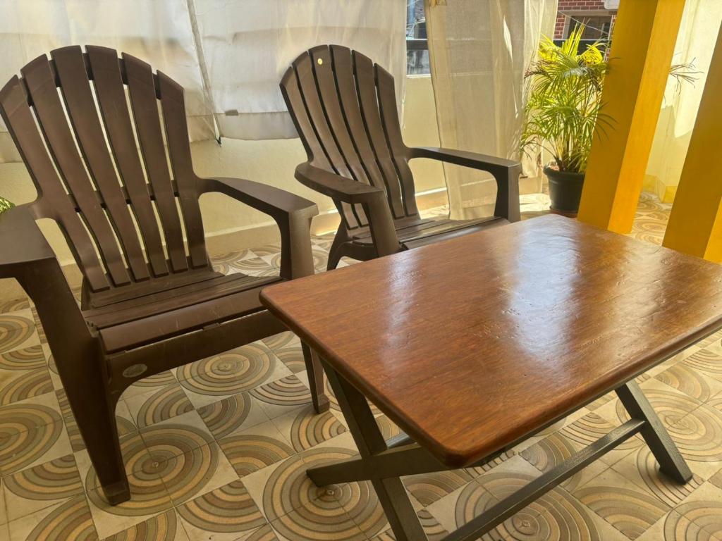 two chairs and a wooden table in a room at Sapthagiri Euphoria in Chikmagalūr