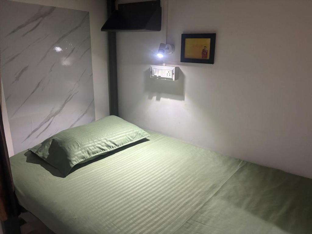 a bedroom with a bed with a green pillow at Sapthagiri Euphoria in Chikmagalūr