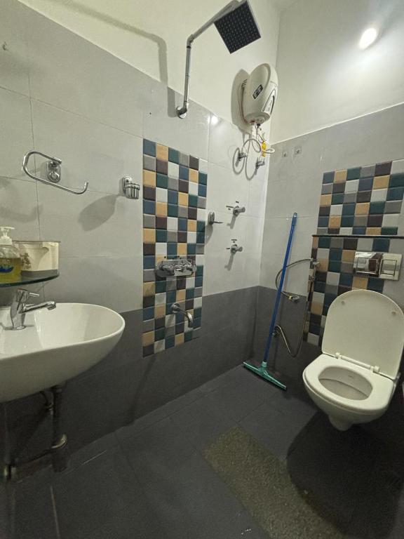 a bathroom with a toilet and a sink at Sapthagiri Euphoria in Chikmagalūr