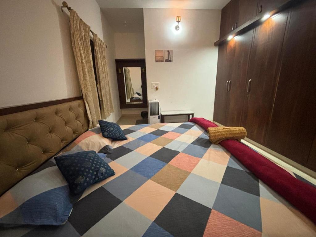 a bedroom with a checkered bed with two pillows at Sapthagiri Euphoria in Chikmagalūr