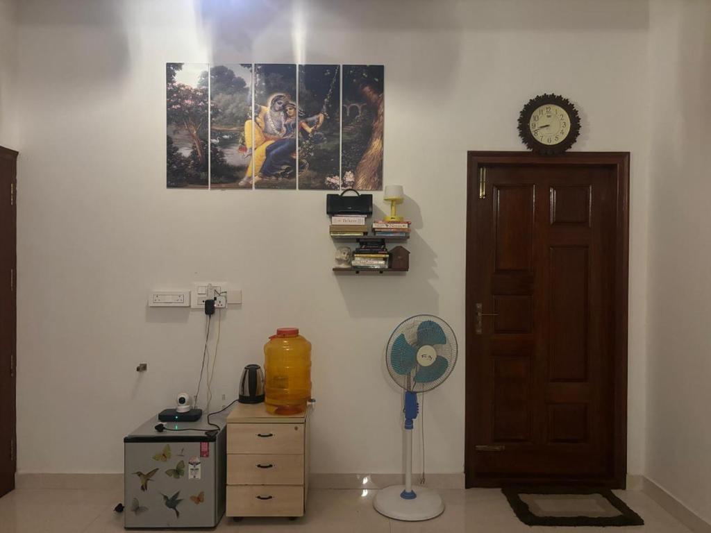 a room with a fan and a clock on the wall at Sapthagiri Euphoria in Chikmagalūr