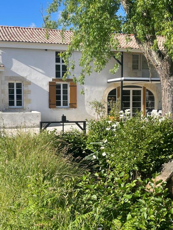 a white house with a tree in front of it at Le domaine du Martinet in Salles
